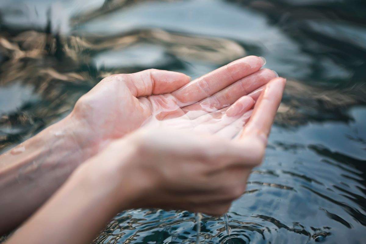 Acqua raccolta tra le mani per bere
