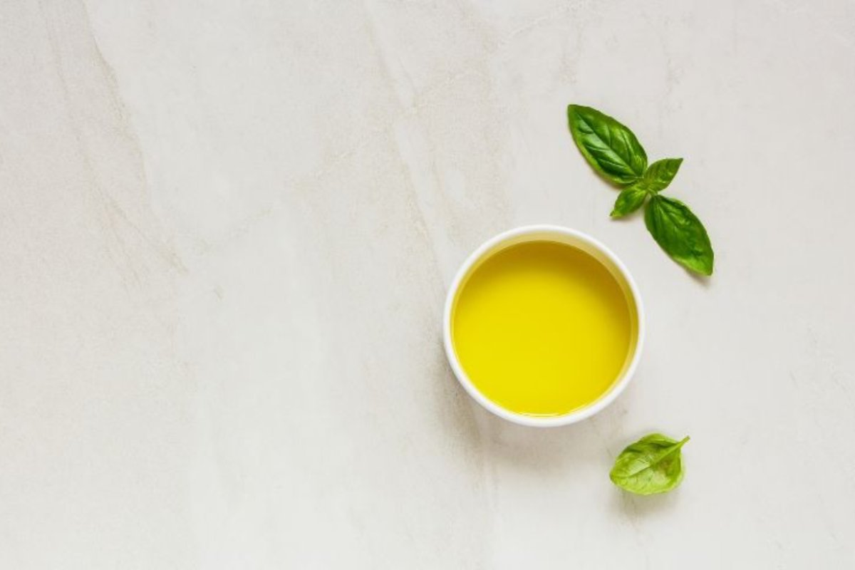 Basilico e olio d'oliva collocati su una superficie 