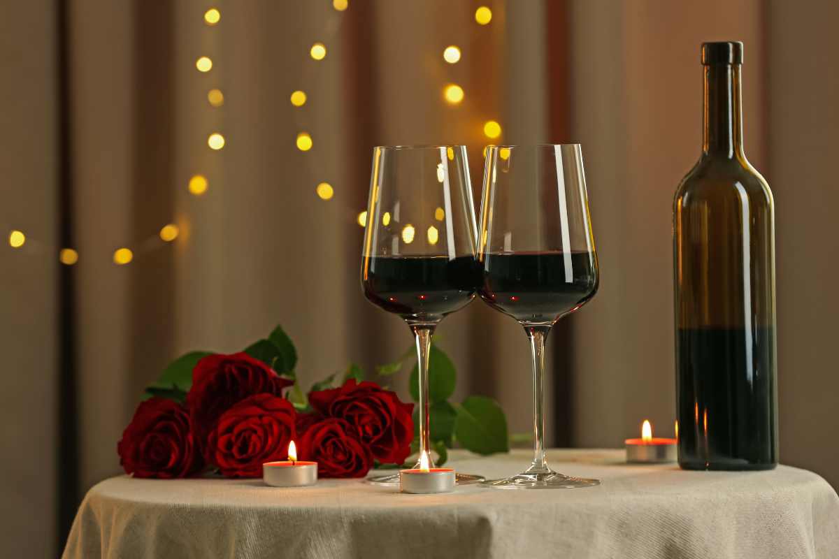 due calici di vino e due rose su un tavolo