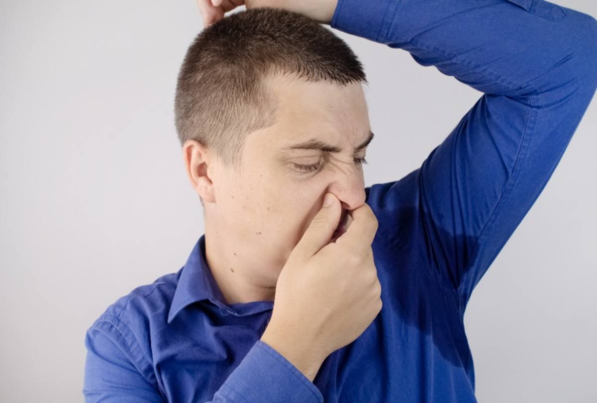 Uomo che copre il naso per il cattivo odore
