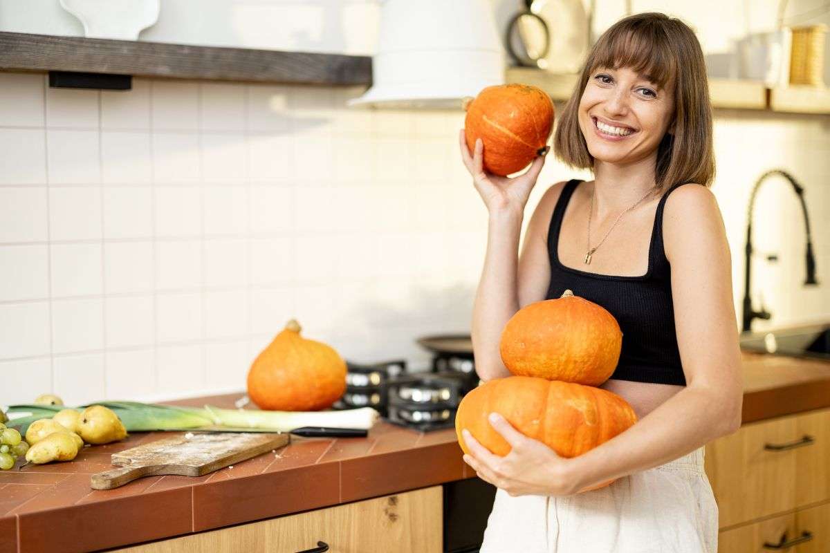 Donna in cucina con le zucche