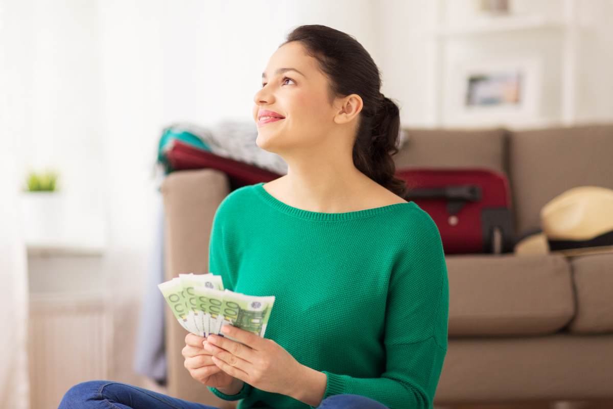 donna con soldi in mano felice